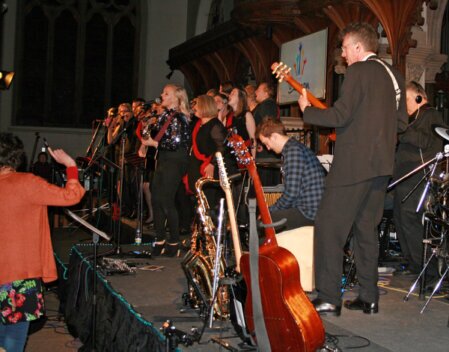 AV crew setting up lighting and speakers on a small stage